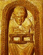 Un monje escribe sobre un atril colocado sobre sus rodillas. Detalle de un relieve de la iglesia de San Vicente, vila (s. XII)